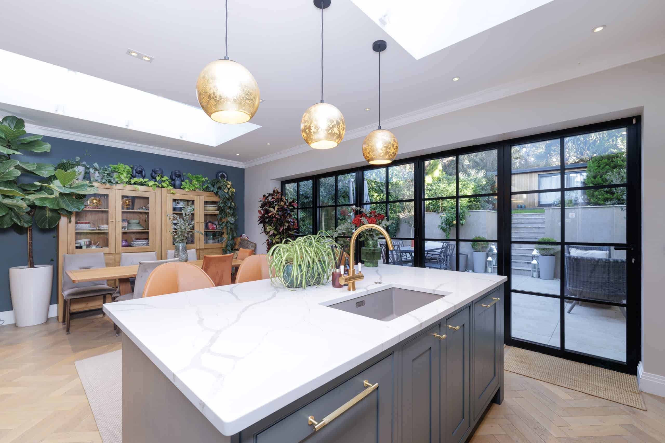 Professional interior property photography of a contemporary kitchen with island and garden access in Hampstead, London.