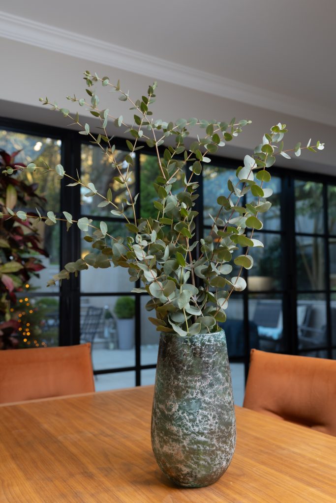 Dining table styled with fresh eucalyptus for a professional property photography session