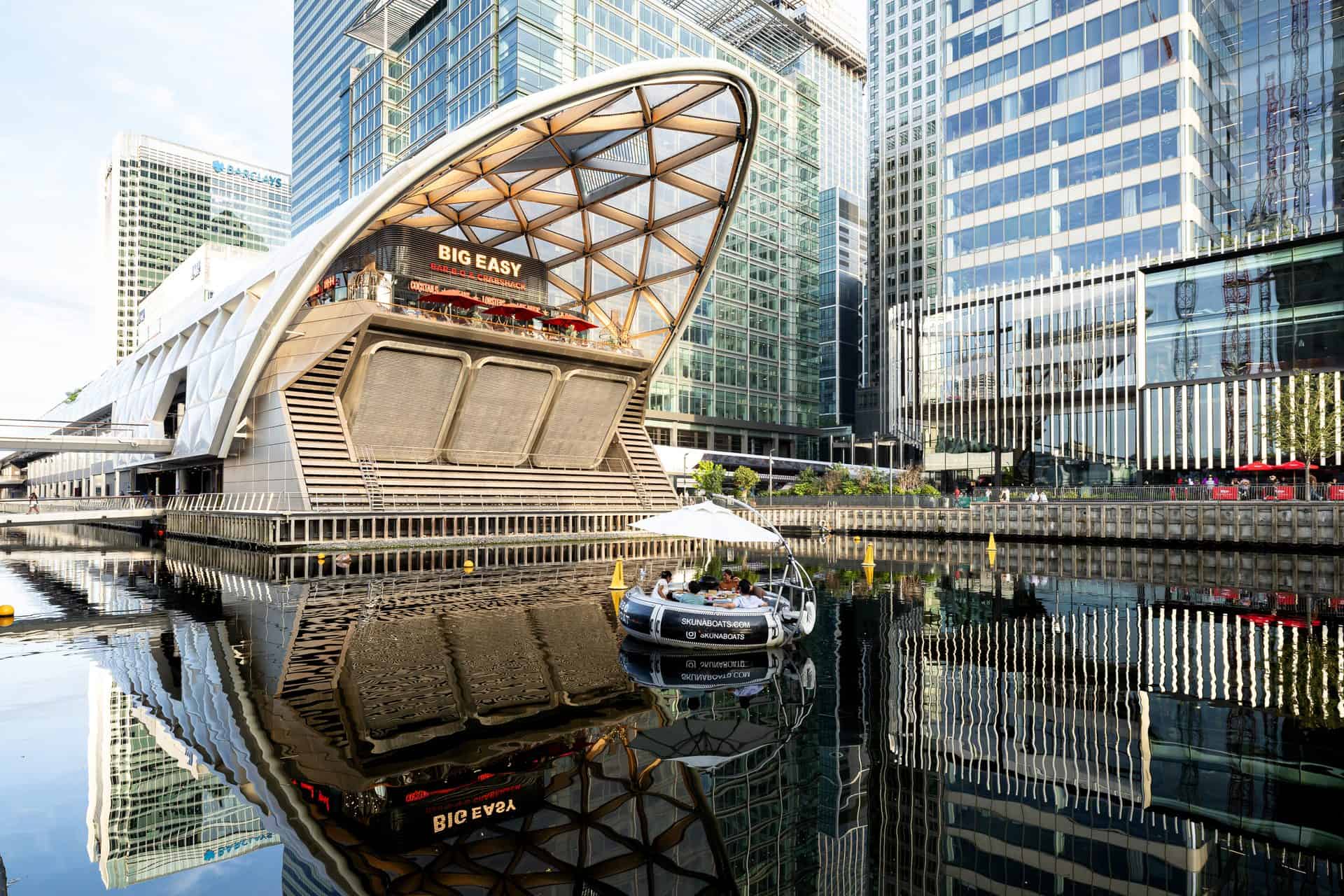 Crossrail Place and office towers reflected in the dock at Canary Wharf, London