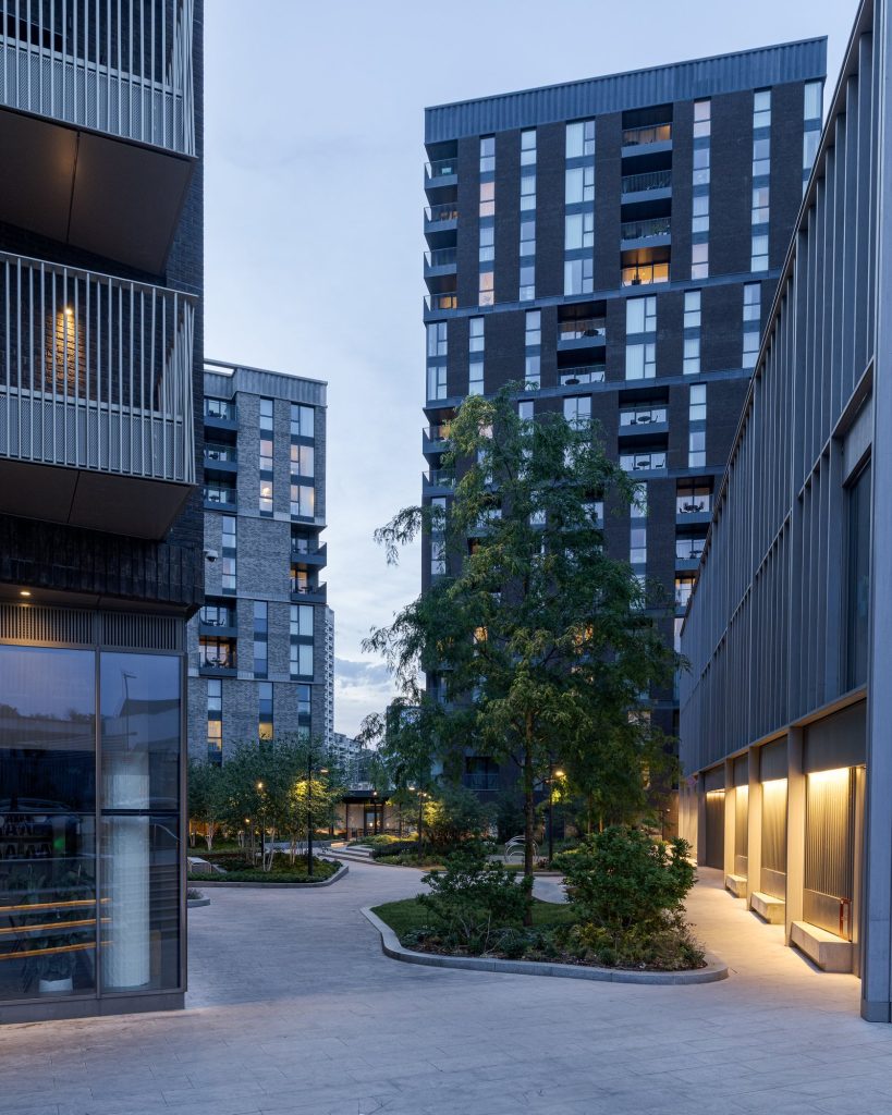 Landscaped courtyard between apartment buildings at Author King’s Cross, London, at twilight