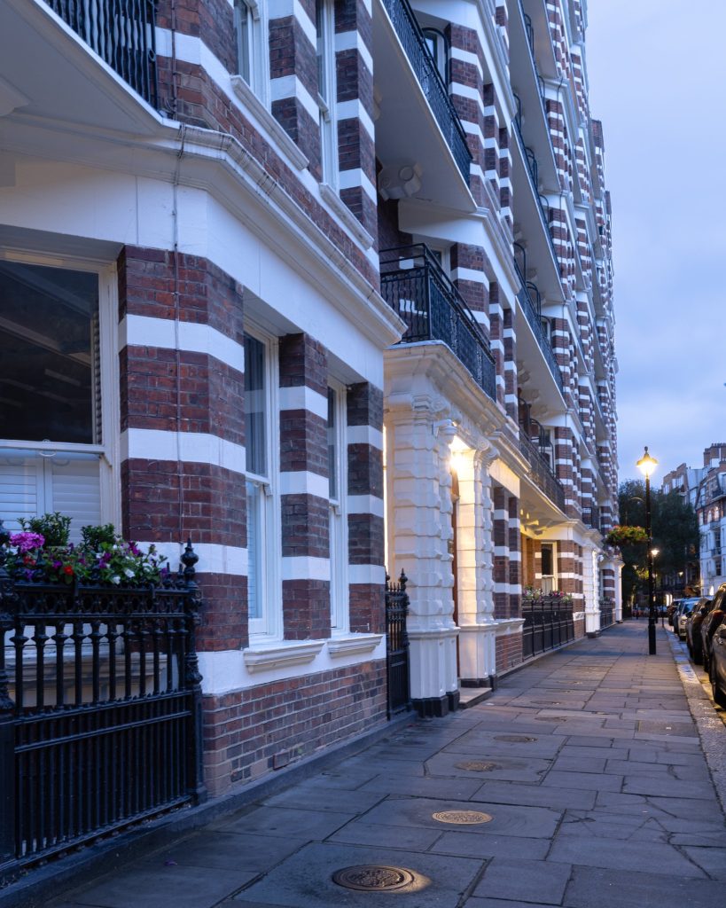 Period red and white brick mansion block on Emery Hill Street, Westminster, photographed at dusk
